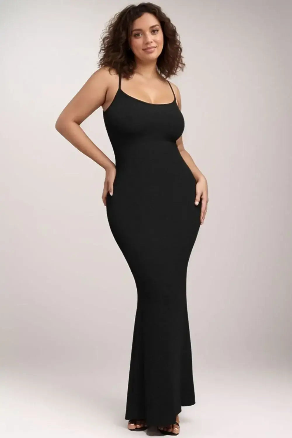 Woman in black sleeveless shapewear maxi dress for a sleek silhouette.